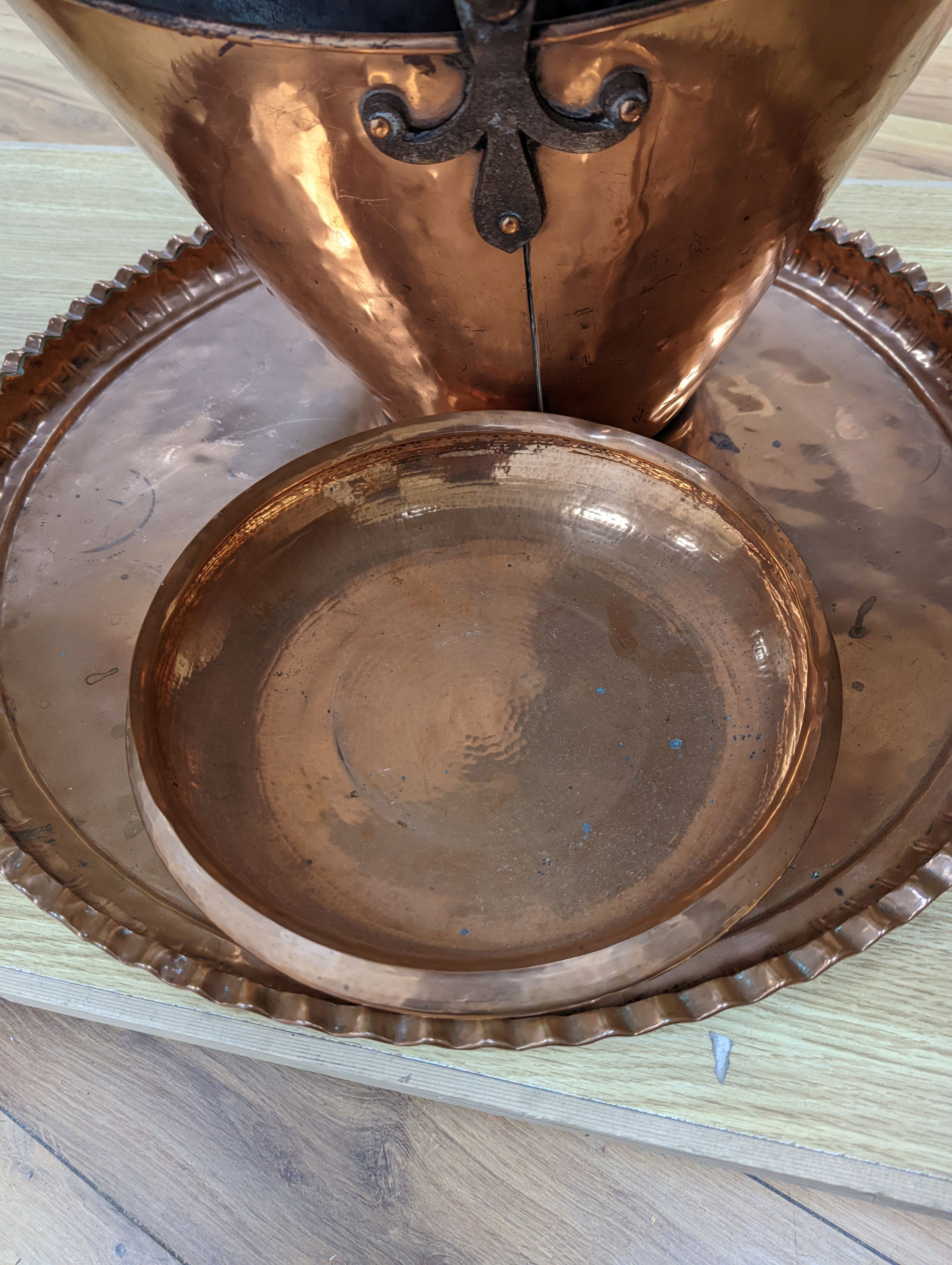 A copper coal scuttle and an Arts and Crafts hammered copper bowl and a similar tray